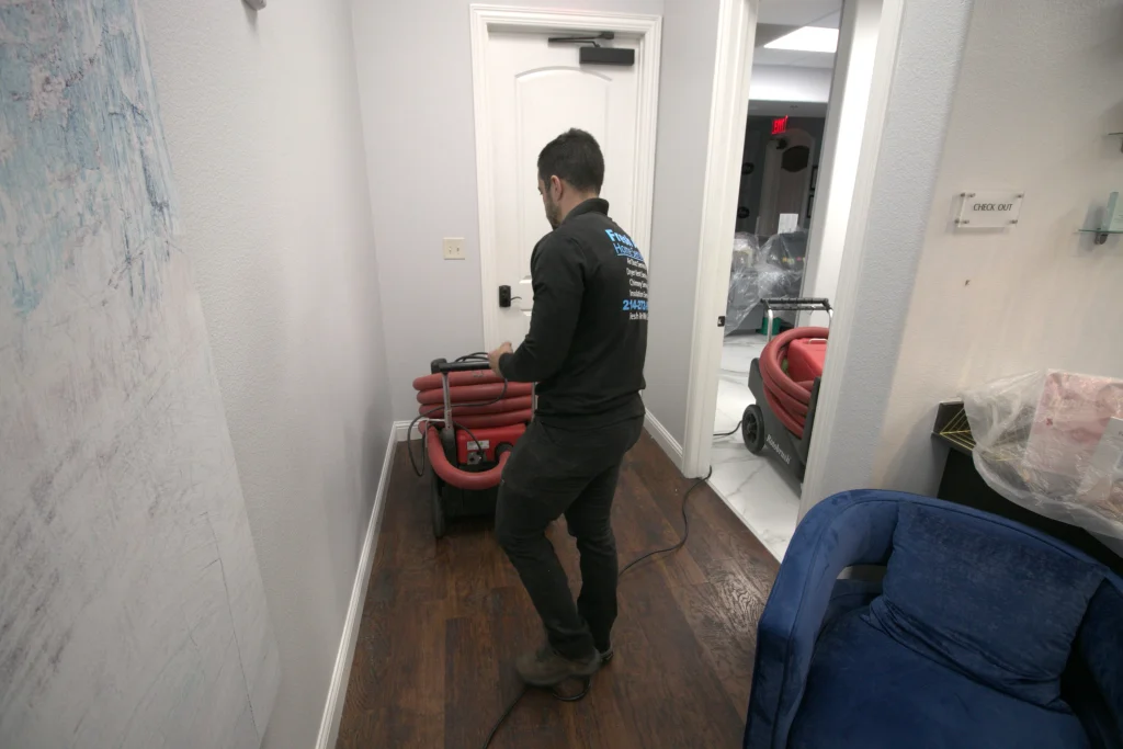 Technician setting up hose equipment for indoor air conditioning cleaning service.