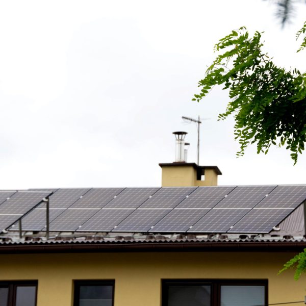 Installing a Solar Cell on a Roof. Solar panels on roof. Historic farm house with modern solar panels on roof and wall. High quality photo